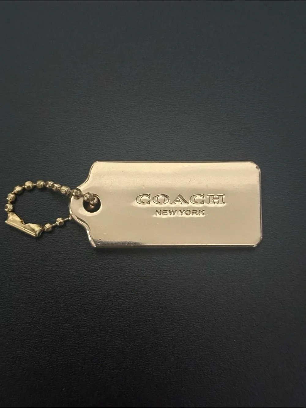Coach gold metal hang tag